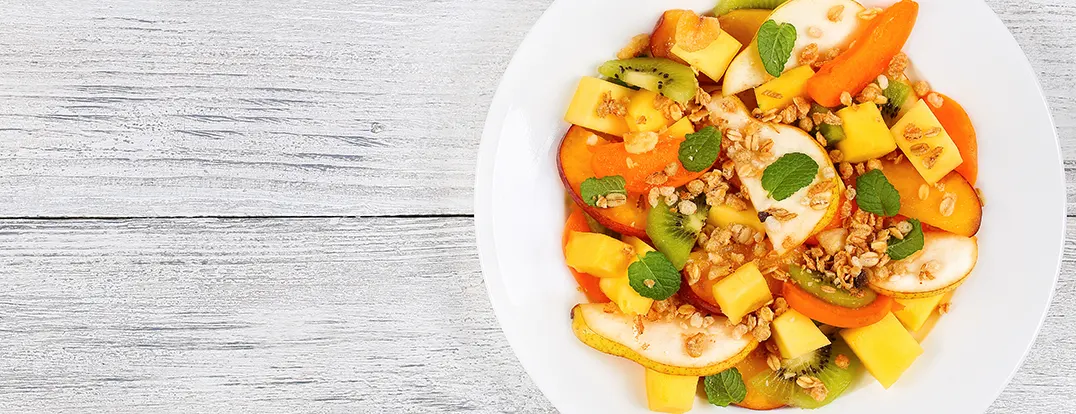 Fruit salad with peach melon and mint leaves